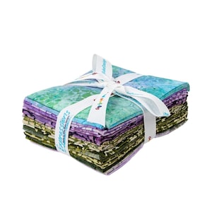 May include: A stack of fabric squares in shades of green, blue, and purple, tied with a white ribbon. The ribbon is printed with the words "Expressions" and "Riley Blake Designs". The fabric has a batik design.