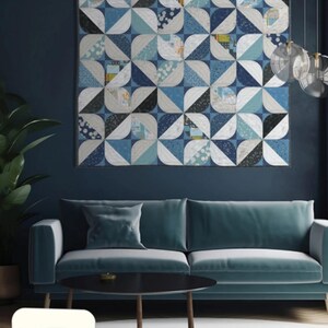 May include: A framed quilt with a geometric pattern in shades of blue, white, and black hangs above a teal sofa. The quilt's design features curved shapes arranged in a grid. The word "LOTUS" is visible in the image.
