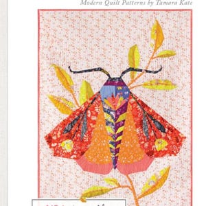 May include: A quilt pattern titled "WONDER GARDEN" by Tamara Kate, featuring a colorful moth design. The moth has orange, red, yellow, and blue wings and is set against a dotted background. The text "NO 1 | the Moth" is displayed below the image, with a quote by Aristotle.