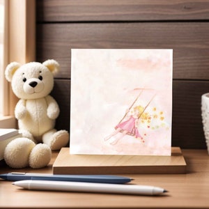 May include: A watercolor painting of a girl with blonde hair swinging on a swing in a pink dress. The background is a soft pink with yellow stars.