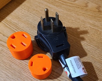 May include: Three orange electrical outlet adapters with a black electrical plug. The adapters have three prongs and the plug has three prongs and a ground.