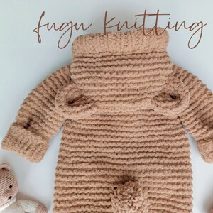 May include: A light brown, knitted baby jumpsuit with a high collar and long sleeves. The jumpsuit has a textured, plush appearance and features a small pocket on the front. The words "fugu knitting" are written in a cursive font.