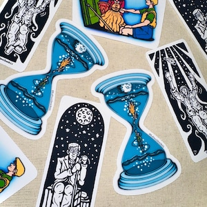 May include: A selection of stickers with quirky illustrations. Designs include a blue hourglass with a person inside, a person reaching for objects, and a scene with two people. The stickers have a white border and are on a neutral background.