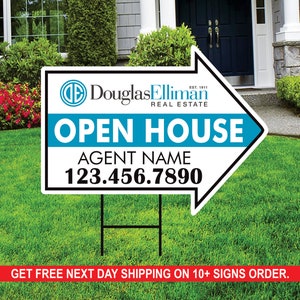 May include: A white and black arrow-shaped real estate open house sign with blue text. The sign says "Douglas Elliman Real Estate" and "Open House". The agent's name and phone number are also included.