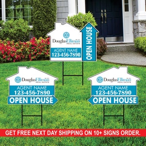 May include: Three white and blue real estate open house signs with a house shape and an arrow. The signs feature the text "Douglas Elliman Real Estate" and "Agent Name 123-456-7890 Open House".