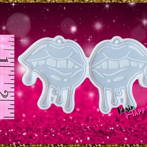 Pu&ograve; includere: Uno stampo in silicone azzurro a forma di due labbra stilizzate con dettagli gocciolanti. Lo stampo &egrave; alto circa 5 cm. Il testo "Resin Happy" &egrave; visibile in basso a destra. Lo sfondo &egrave; rosa glitterato.