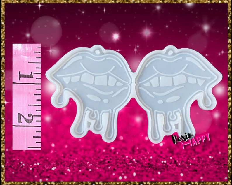 Pu&ograve; includere: Uno stampo in silicone azzurro a forma di due labbra stilizzate con dettagli gocciolanti. Lo stampo &egrave; alto circa 5 cm. Il testo "Resin Happy" &egrave; visibile in basso a destra. Lo sfondo &egrave; rosa glitterato.