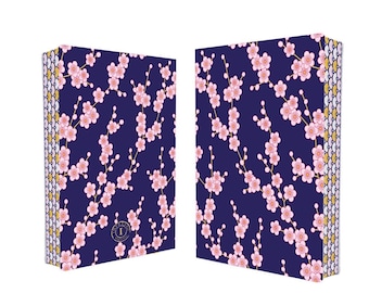 May include: Two rectangular notebooks with a navy blue background and a pattern of pink cherry blossoms. The spine has a gold, white, and yellow scale design. The notebooks are side by side, angled slightly away from each other.