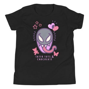 May include: Black youth t-shirt with a pink cartoon Venom character with a pink tongue, pink hearts, stars, and a teddy bear. The text "Tater Tots & Chocolate" is printed below the character.
