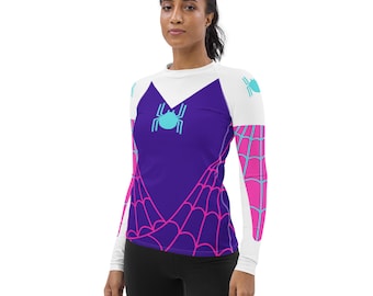 May include: White long-sleeved shirt with a purple and pink spiderweb design. The shirt features a blue spider graphic on the front.
