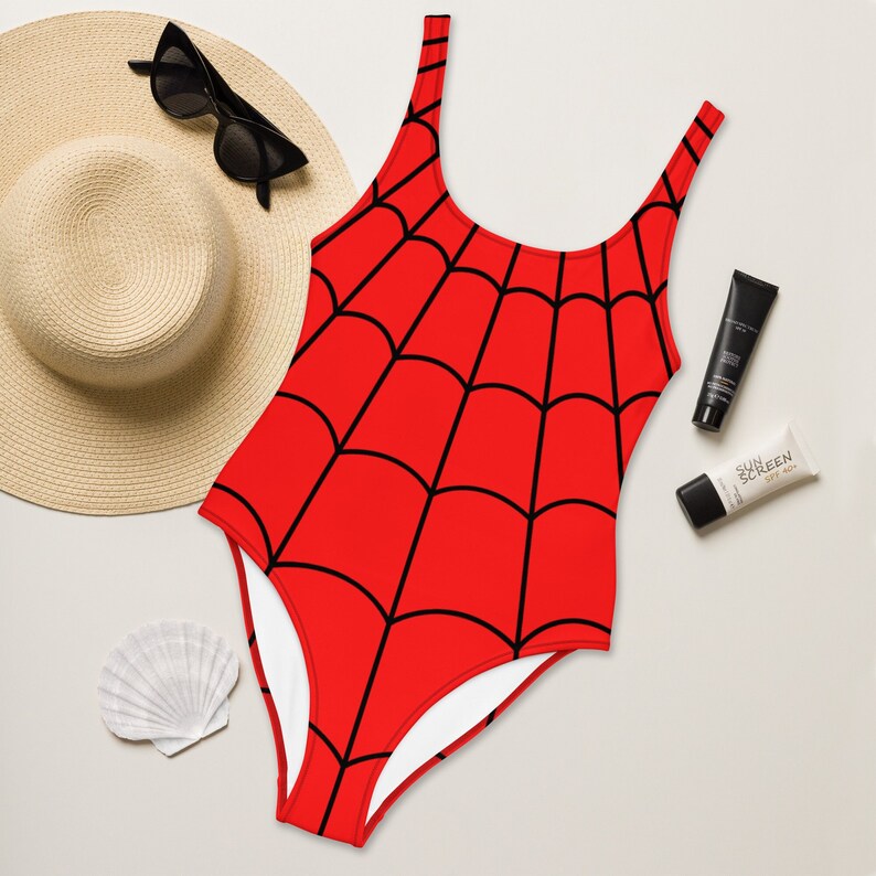 Puede incluir: Traje de ba&ntilde;o rojo con un dise&ntilde;o de telara&ntilde;a negra.