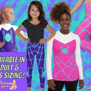 Op de afbeelding: Drie mensen dragen leggings met een spinnenweb- en spinnenontwerp. De leggings zijn verkrijgbaar in volwassen- en kindermaten. De leggings zijn paars, roze en wit met een blauwe spin.
