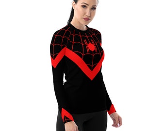 Puede incluir: Camiseta negra de manga larga con un diseño de telaraña roja y una araña roja en el centro. La camiseta tiene un patrón de chevron rojo en la parte delantera.