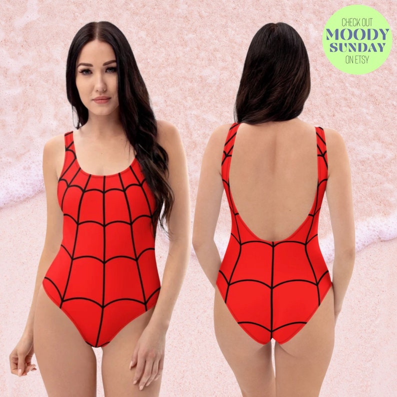 Puede incluir: Traje de ba&ntilde;o rojo con un dise&ntilde;o de telara&ntilde;a negra. El traje de ba&ntilde;o tiene un escote redondo y una espalda baja.