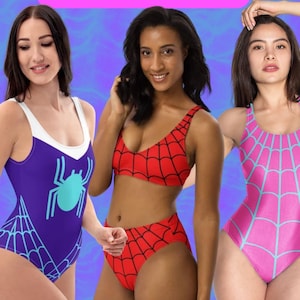 May include: Three women wearing different swimsuit styles featuring a spider web design. One swimsuit is purple with a turquoise spider, another is a red and black two-piece, and the third is pink with a light blue spider web.
