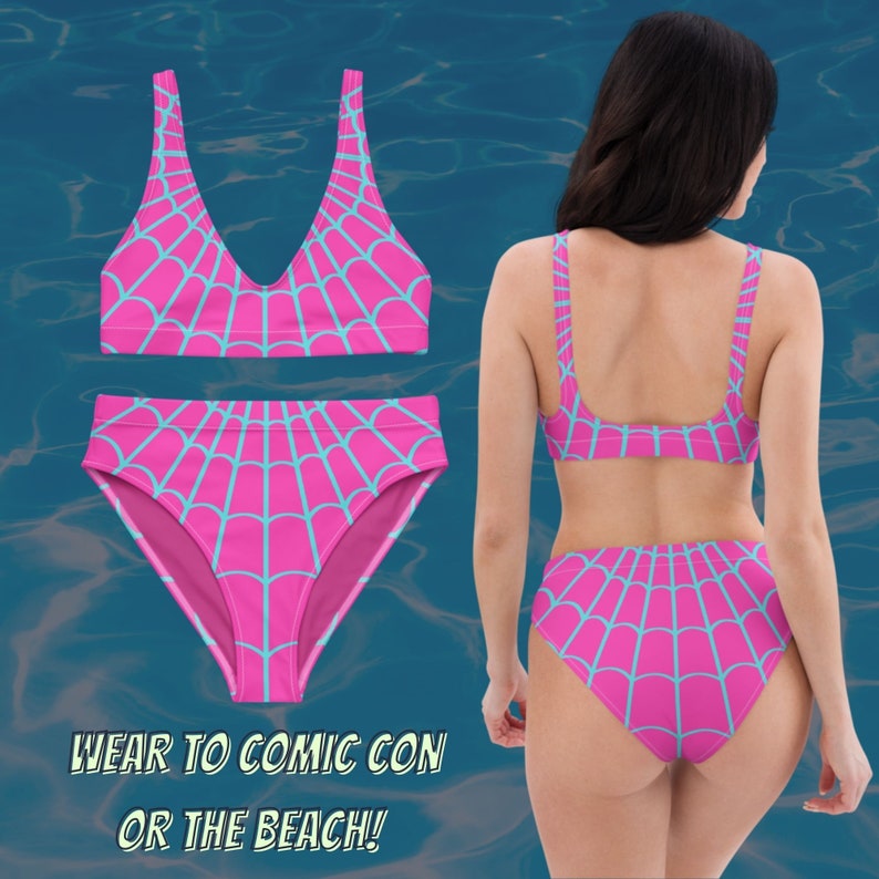 Puede incluir: Traje de ba&ntilde;o rosa y azul con un patr&oacute;n de telara&ntilde;a. El traje de ba&ntilde;o tiene un top halter y una parte inferior de cintura alta. "&iexcl;&Uacute;salo para Comic Con o la playa!" est&aacute; escrito en la imagen.