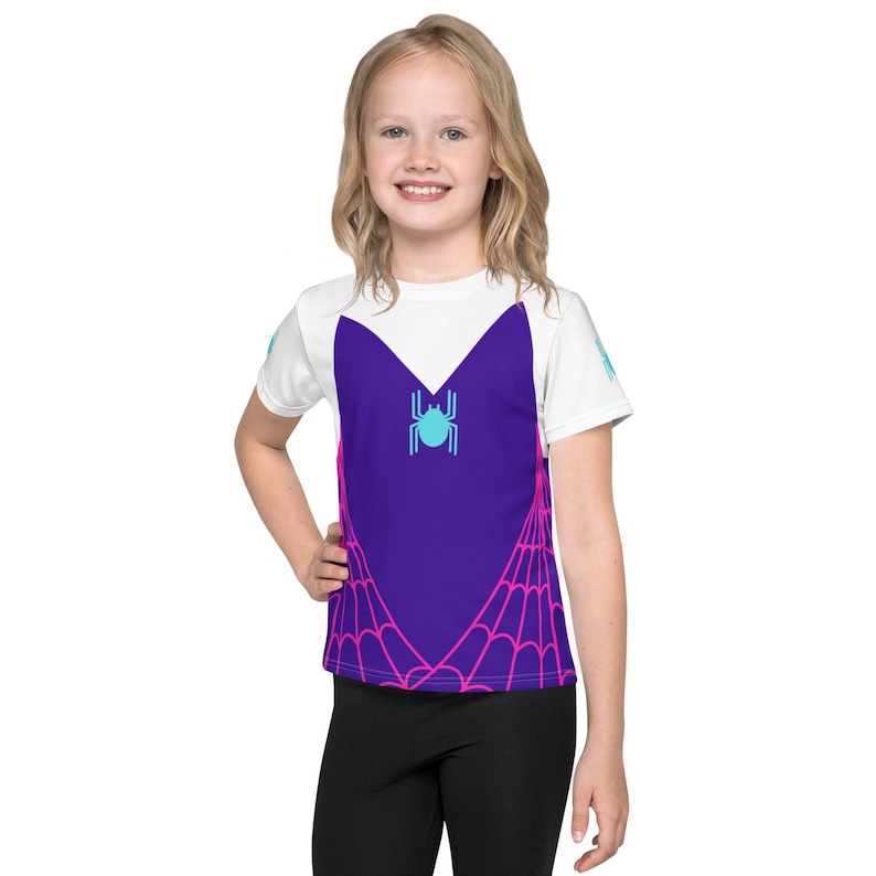 May include: White short-sleeved t-shirt with a purple and pink spiderweb design and a blue spider in the center.