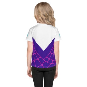 K&ouml;nnte beinhalten: Wei&szlig;es T-Shirt f&uuml;r Jugendliche mit einem lila und pinkfarbenen Spinnennetz-Design auf der R&uuml;ckseite. Das Design zeigt ein wei&szlig;es V in der Mitte.