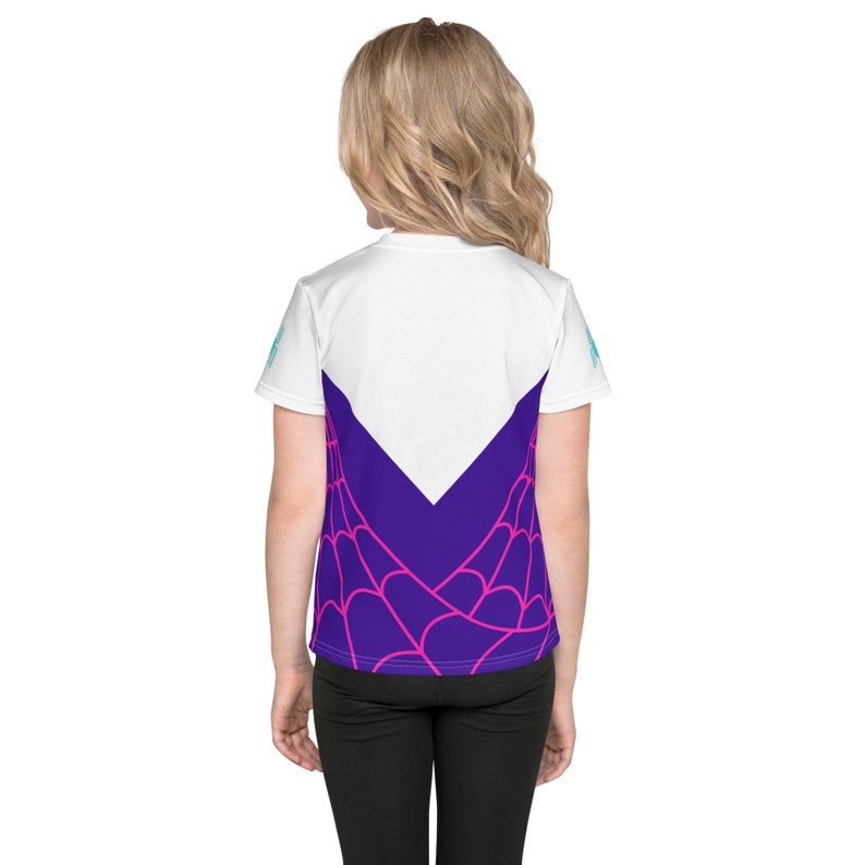 May include: White youth t-shirt with a purple and pink spiderweb design on the back. The design features a white V-shape in the center.