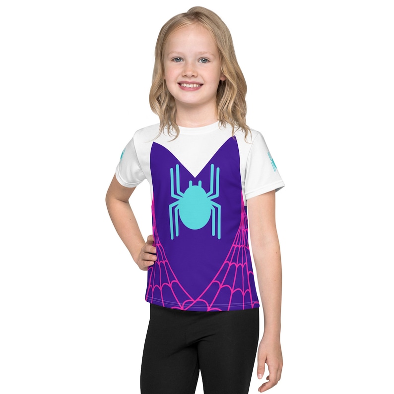 K&ouml;nnte beinhalten: Wei&szlig;es T-Shirt mit kurzen &Auml;rmeln mit einem Spinnennetz-Design in Lila und Pink und einer blauen Spinne in der Mitte.