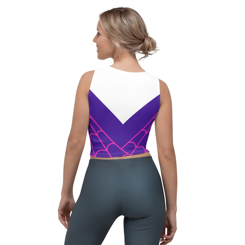 Puede incluir: Un top corto blanco con un dise&ntilde;o de telara&ntilde;a p&uacute;rpura y rosa. El top tiene un escote redondo y es sin mangas.