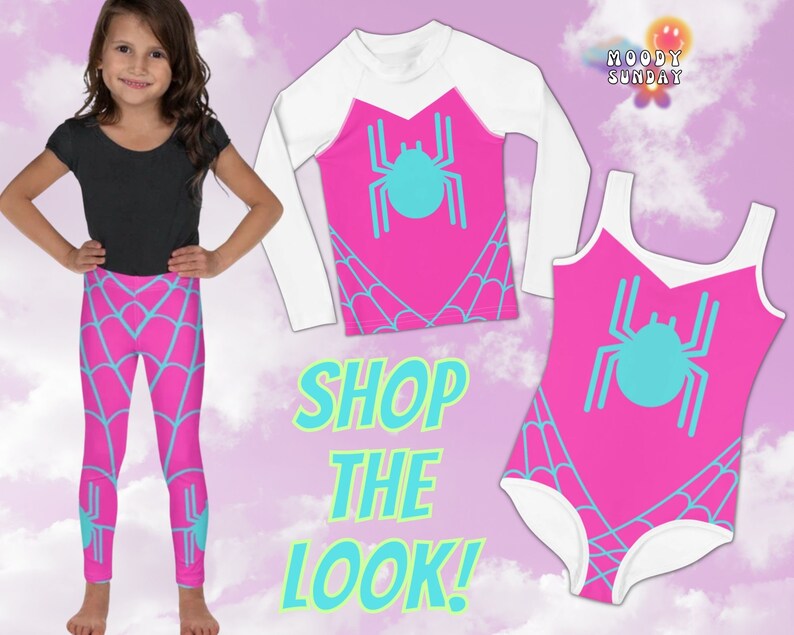 Op de afbeelding: Een roze en blauwe outfit voor kinderen met een spinnenweb-thema. De outfit bestaat uit een shirt met lange mouwen, leggings en een badpak. Het shirt heeft een witte lange mouw en een roze voorkant met een blauwe spin-afbeelding. De leggings zijn roze met een blauw spinnenweb-ontwerp. Het badpak is roze met een blauwe spin-afbeelding en een witte rand. De tekst "SHOP THE LOOK!" is geschreven in groen en blauw.