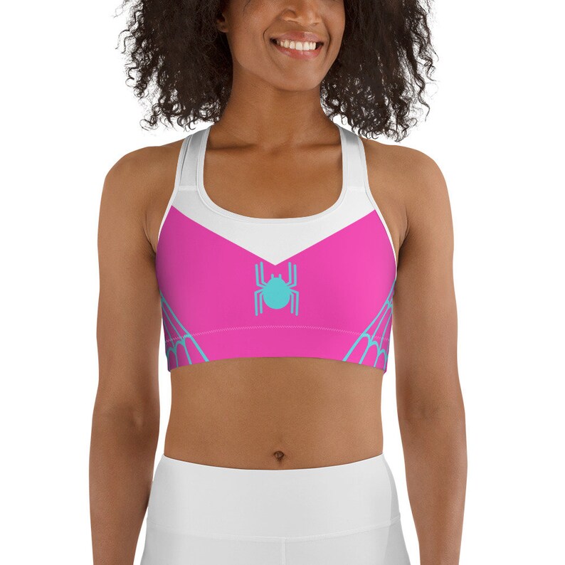 May include: Pink and white sports bra with a blue spider web design and a blue spider in the center.