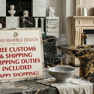 Puede incluir: Un letrero rectangular blanco con borde dorado muestra el texto OMAS MARBLE DESIGN en rojo oscuro, seguido de un texto rojo que dice FREE CUSTOMS & SHIPPING SHIPPING DUTIES INCLUDED HAPPY SHOPPING! El letrero se encuentra sobre una superficie de m&aacute;rmol negro y oro.