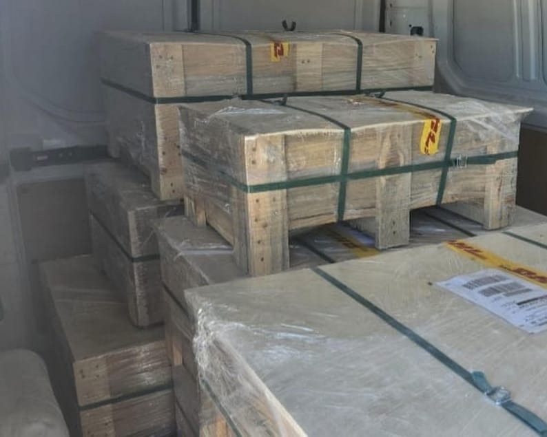 Pu&ograve; includere: Casse di legno impilate con nastro adesivo marrone e un'etichetta gialla con il testo "72". Le casse sono riempite con vari articoli, probabilmente per la spedizione.