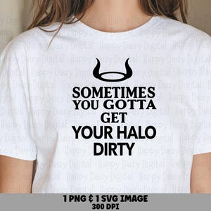 May include: A white short-sleeved t-shirt featuring a black graphic of a halo with horns above the text that reads: SOMETIMES YOU GOTTA GET YOUR HALO DIRTY. The design is centered on the chest area of the garment in a bold, black sans-serif font.