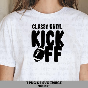 May include: A white short-sleeved t-shirt featuring black text that reads "CLASSY UNTIL KICK OFF" with a black football graphic replacing the letter "O" in the word "KICK". The design is centered on the chest of the garment.