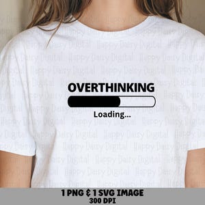 May include: A white short-sleeved t-shirt featuring a black graphic print on the chest. The design displays the word OVERTHINKING above a horizontal loading bar that is partially filled, with the word Loading... printed underneath the bar.