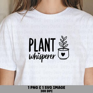 Peut inclure: Un t-shirt blanc à manches courtes avec une impression graphique noire. Le texte indique "PLANT whisperer" dans un mélange de polices bâton et manuscrite, accompagné d'une illustration au trait d'une plante en pot avec un petit cœur.
