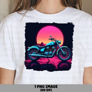 May include: A white t-shirt featuring a graphic print of a blue motorcycle parked against a large, vibrant pink sun. The design includes a dark background with a reflection of the motorcycle on the ground and distant mountain silhouettes.