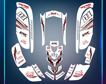 May include: A collection of white, red, and black graphic decals for a vehicle. The decals feature the number "01", the "FOX" logo, and the text "RAPTOR", "PITSTER PRO", "PRO CIRCUIT", and "Mhio's GRAPHIC". The image also includes the text "MADE IN USA" and "100% CUSTOMIZABLE".