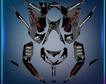 May include: A black and grey graphic design for a Yamaha Raptor 700 ATV. The design features the words "Raptor" and "Yamaha" in red, along with other sponsors and logos. The design is made for a dirt bike and has a grunge aesthetic.