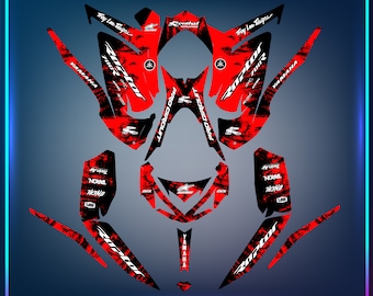 May include: Red, black and white graphic design for a Yamaha Raptor 700 ATV. The design features a camouflage pattern with the words "Raptor" and "Troy Lee Designs" in white lettering.
