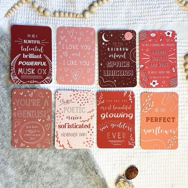 May include: Set of eight affirmation cards with colorful backgrounds and white text. The cards feature positive messages such as "You are a genius!" and "Oh you perfect sunflower!"