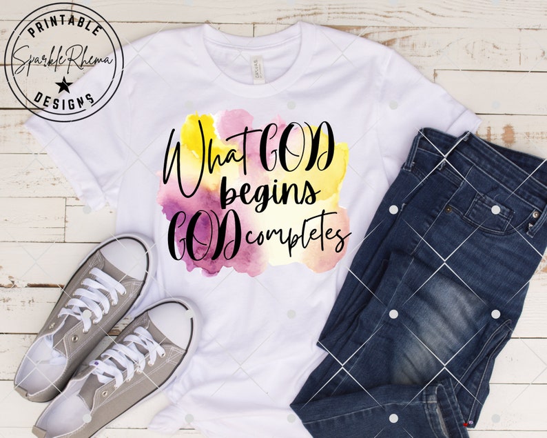 May include: White t-shirt with a watercolor design and the text "What God begins God completes".