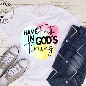 May include: White t-shirt with a watercolor design featuring the text "Have Faith in God's Timing".