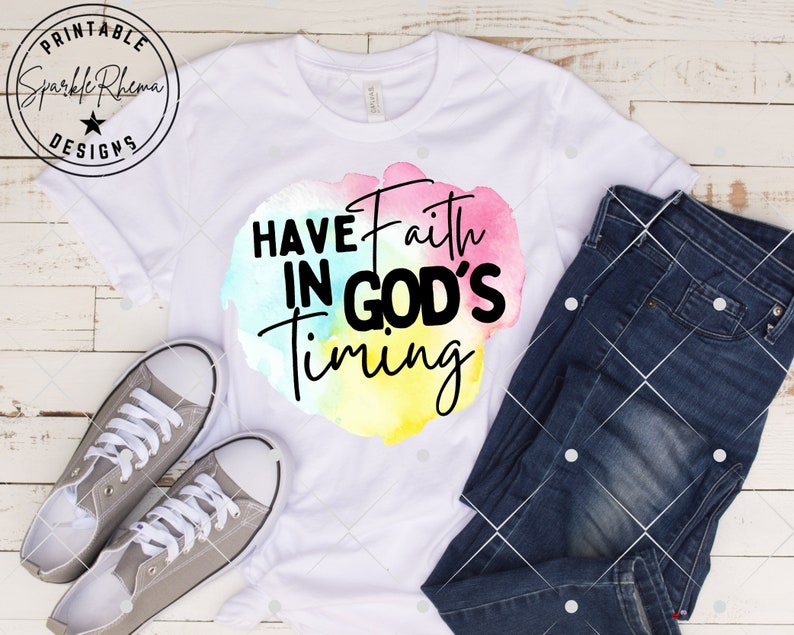 May include: White t-shirt with a watercolor design featuring the text "Have Faith in God's Timing".