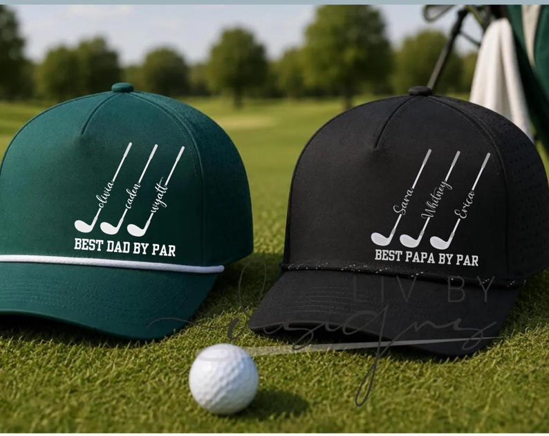 May include: Two golf caps, one dark green and one black, with white text and golf club graphics. The green cap says "BEST DAD BY PAR" with names. The black cap says "BEST PAPA BY PAR" with names. A golf ball rests on the grass.