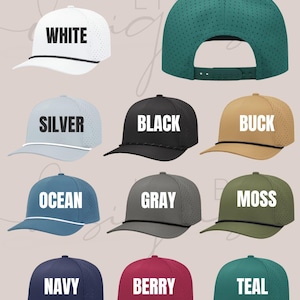 May include: A collection of ten baseball caps in various colors, including white, silver, black, buck, ocean, gray, moss, navy, berry, and teal. Each cap features a perforated design, a curved brim, and the color name printed on the front.