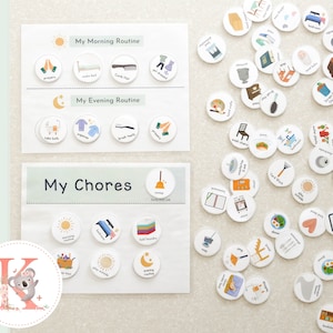 May include: A set of colorful, illustrated, round, magnetic tokens with various images, such as a bed, a toothbrush, a broom, a washing machine, and a plate of food. The tokens are arranged on a white surface with two white cards with the titles "My Morning Routine", "My Evening Routine", and "My Chores".
