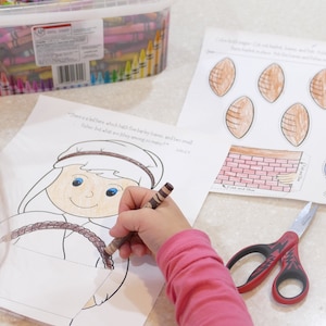 Pu&ograve; includere: Un bambino colora una pagina da colorare stampabile di una persona con una corda. La pagina include il testo "C'&egrave; un bambino piccolo che ha due pani d'orzo e cinque pesci piccoli: ma cosa sono tra tanti?" Una seconda pagina stampabile mostra un muro di mattoni, pesci e palloni da calcio da ritagliare e colorare.