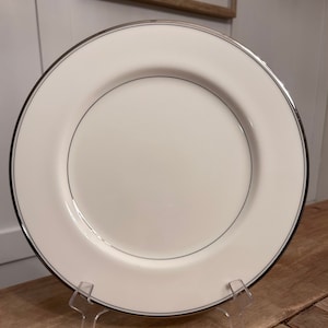 Op de afbeelding: Een wit keramisch dinerbord met een dunne zilveren rand.