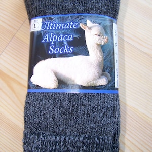 May include: A pair of gray alpaca socks with a label that says "Ultimate Alpaca Socks" and features a white alpaca. The label also indicates the size is L.