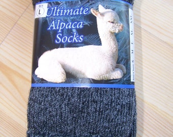 May include: A pair of gray alpaca socks with a label that says "Ultimate Alpaca Socks" and features a white alpaca. The label also indicates the size is L.