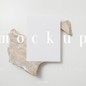 May include: A white 5x7 card mockup on a light gray background with a beige rock on the left and a smaller beige rock on the right. The text "mockup" is printed in white on the background.