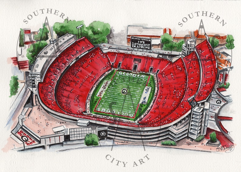 May include: Watercolor painting of a football stadium with red seating and a green field. The words "GEORGIA" and "BULLDOGS" are visible on the field. The text "IT'S SATURDAY IN ATHENS" is displayed above the stadium.